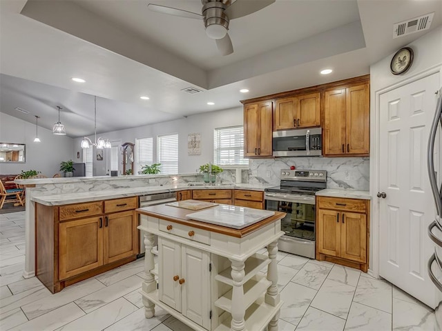 1466 County Rd 1188, Tuttle, OK 73089 - kitchen with appliances with stainless steel finishes, a peninsula, light marble finish floors, recessed lighting, and ceiling fan