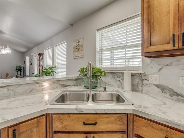 1466 County Rd 1188, Tuttle, OK 73089 - kitchen with lofted ceiling, healthy amount of natural light, brown cabinetry, and tasteful backsplash