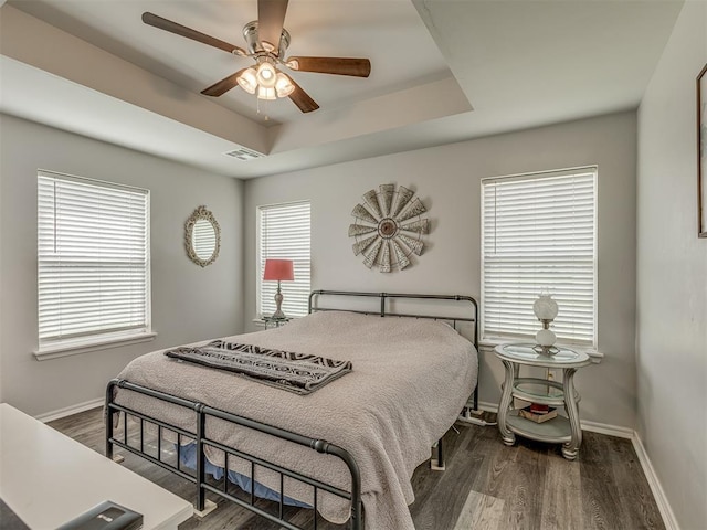 1466 County Rd 1188, Tuttle, OK 73089 - bedroom featuring dark wood-style flooring, a raised ceiling, and a ceiling fan