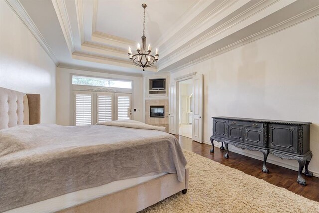 14812 Maplelake Dr, Edmond, OK 73013 - bedroom featuring crown molding, a chandelier, dark wood-type flooring, and a tray ceiling
