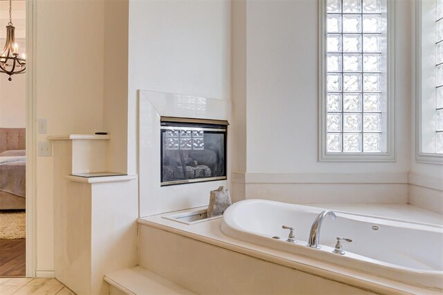 14812 Maplelake Dr, Edmond, OK 73013 - ensuite bathroom with a garden tub and a glass covered fireplace