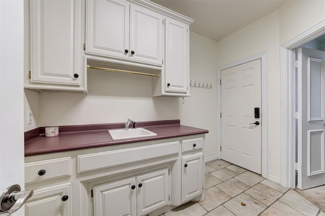 14812 Maplelake Dr, Edmond, OK 73013 - kitchen with a sink, dark countertops, white cabinetry, and light tile patterned floors