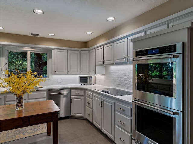 2901 NE 122nd St, Edmond, OK 73013 - kitchen featuring stainless steel appliances, light countertops, tasteful backsplash, recessed lighting, and tile patterned floors