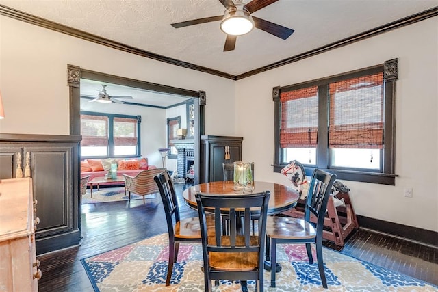 1217 NW 44th St, Oklahoma City, OK 73118 - dining space featuring a ceiling fan, dark wood-type flooring, ornamental molding, and a fireplace