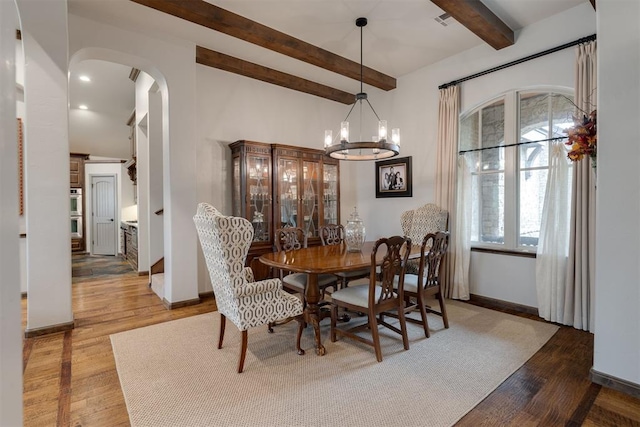 7616 NW 134th St, Oklahoma City, OK 73142 - dining area with arched walkways, beam ceiling, wood finished floors, baseboards, and a chandelier