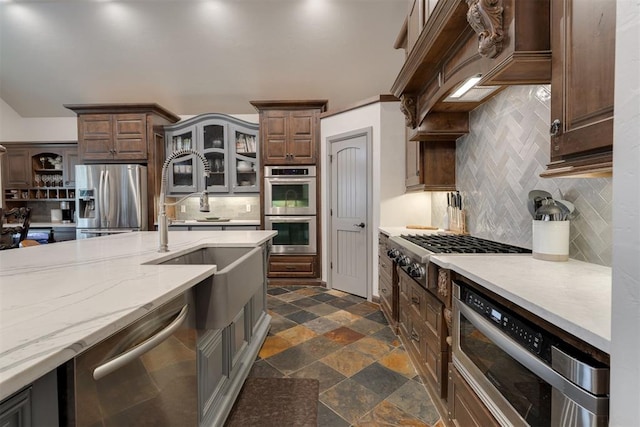7616 NW 134th St, Oklahoma City, OK 73142 - kitchen with stainless steel appliances, decorative backsplash, dark stone finish floors, light stone counters, and a sink