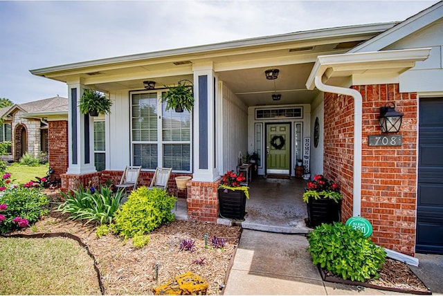708 Ashwood Ln, Moore, OK 73160 - view of exterior entry with brick siding and a porch