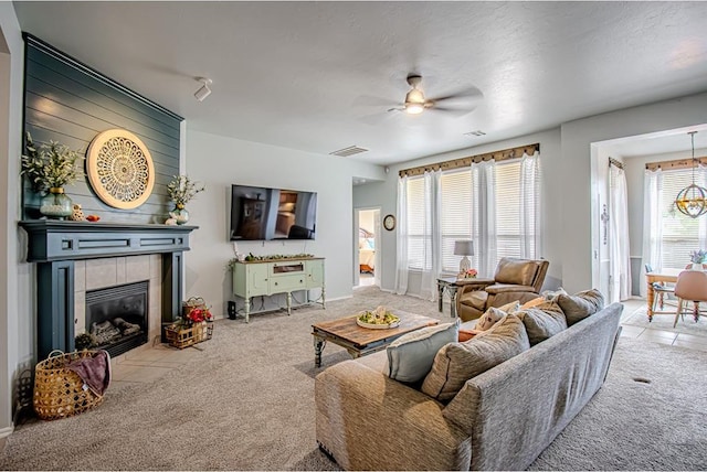 708 Ashwood Ln, Moore, OK 73160 - carpeted living area featuring a tile fireplace, a ceiling fan, and a chandelier