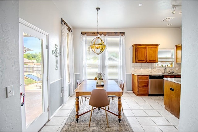 708 Ashwood Ln, Moore, OK 73160 - dining area featuring light tile patterned flooring, plenty of natural light, a chandelier, a textured wall, and baseboards