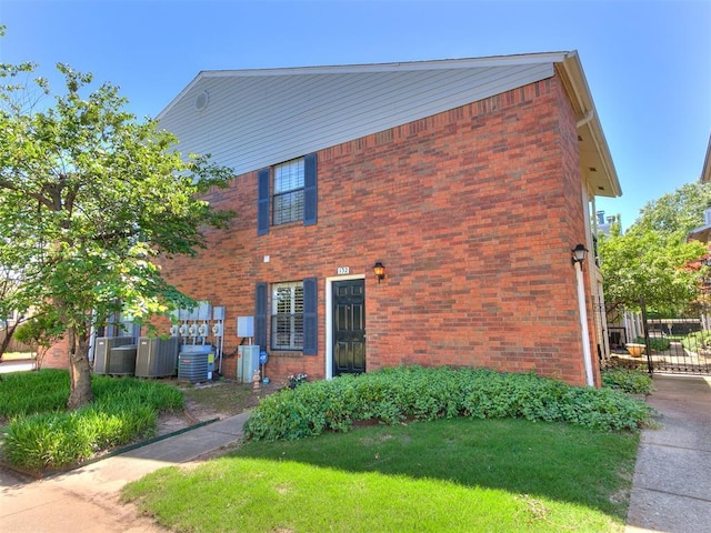 3000 Chautauqua Ave Unit 132, Norman, OK 73072 - view of front of house featuring brick siding, central AC unit, and a front yard