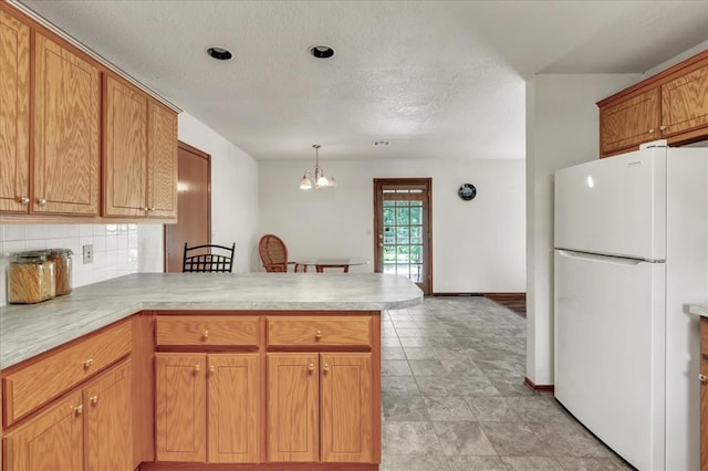 826 Stone Dr, Blanchard, OK 73010 - kitchen with freestanding refrigerator, a peninsula, light countertops, backsplash, and a textured ceiling