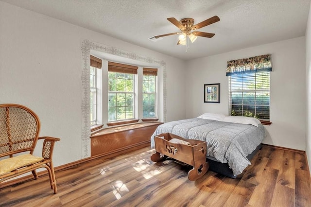 826 Stone Dr, Blanchard, OK 73010 - bedroom with wood finished floors, a textured ceiling, and ceiling fan
