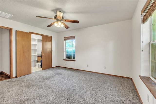 826 Stone Dr, Blanchard, OK 73010 - unfurnished bedroom featuring carpet, multiple closets, ceiling fan, baseboards, and a textured ceiling