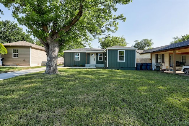 737 NW 89th St, Oklahoma City, OK 73114 - view of front of home with board and batten siding and a front yard
