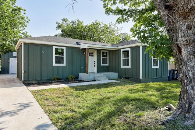 737 NW 89th St, Oklahoma City, OK 73114 - view of front of house featuring board and batten siding, a front lawn, a shingled roof, an outdoor structure, and crawl space