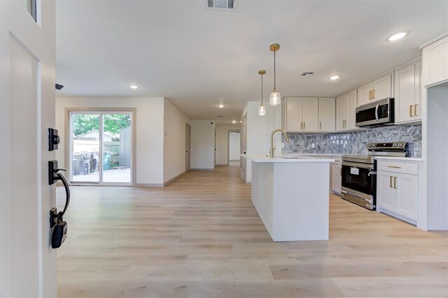 737 NW 89th St, Oklahoma City, OK 73114 - kitchen featuring stainless steel appliances, backsplash, light countertops, light wood-style floors, and white cabinetry