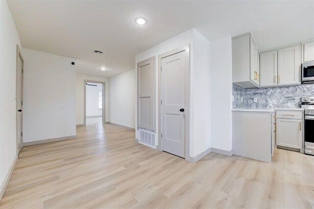 737 NW 89th St, Oklahoma City, OK 73114 - kitchen with appliances with stainless steel finishes, light wood-style flooring, decorative backsplash, light countertops, and recessed lighting