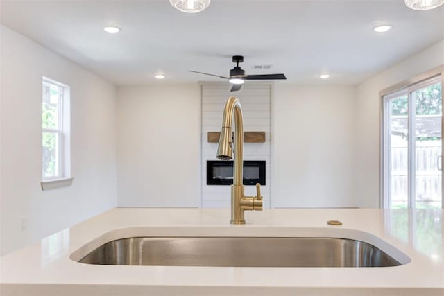 737 NW 89th St, Oklahoma City, OK 73114 - kitchen featuring a sink, a large fireplace, recessed lighting, light countertops, and a ceiling fan