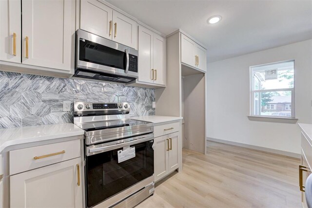737 NW 89th St, Oklahoma City, OK 73114 - kitchen with appliances with stainless steel finishes, backsplash, light countertops, light wood-type flooring, and white cabinets