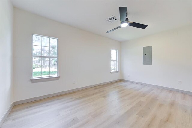 737 NW 89th St, Oklahoma City, OK 73114 - empty room featuring electric panel, light wood-type flooring, and plenty of natural light