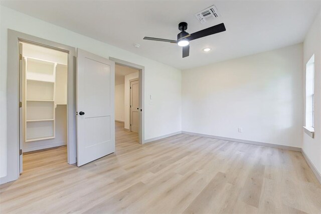 737 NW 89th St, Oklahoma City, OK 73114 - unfurnished bedroom with a walk in closet, light wood-style flooring, baseboards, ceiling fan, and multiple windows