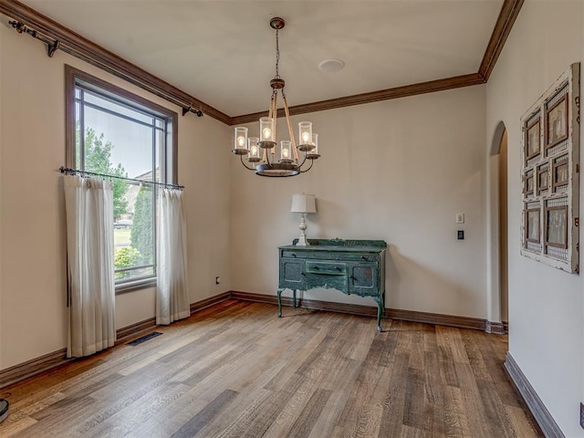 4401 Cannon Dr, Norman, OK 73072 - empty room with crown molding, arched walkways, a chandelier, and wood finished floors