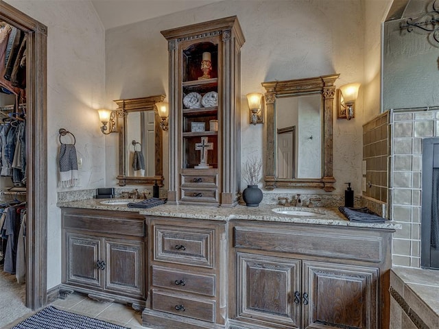 4401 Cannon Dr, Norman, OK 73072 - bathroom featuring double vanity, a walk in closet, vaulted ceiling, and a textured wall