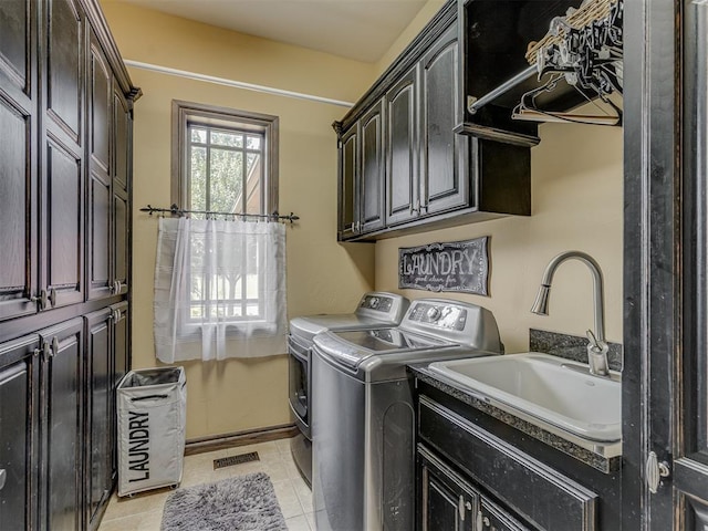 4401 Cannon Dr, Norman, OK 73072 - laundry area with washer and clothes dryer, cabinet space, and light tile patterned floors