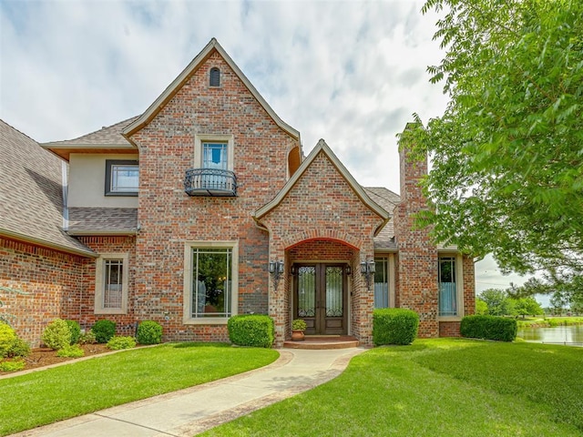 4401 Cannon Dr, Norman, OK 73072 - view of front of property featuring french doors, brick siding, a front lawn, and a shingled roof