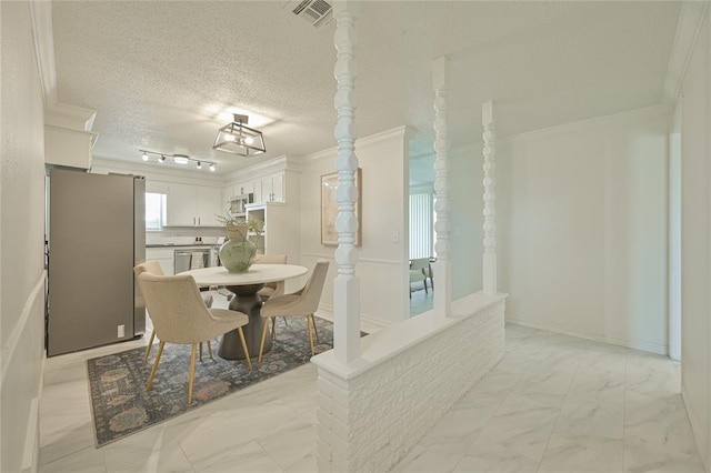 121 NW 79th St, Oklahoma City, OK 73114 - dining space with crown molding, light marble finish floors, and a textured ceiling
