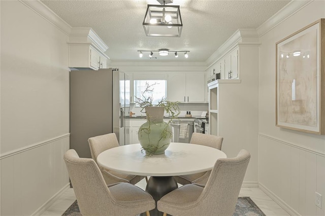 121 NW 79th St, Oklahoma City, OK 73114 - dining room with a textured ceiling, crown molding, a decorative wall, and wainscoting