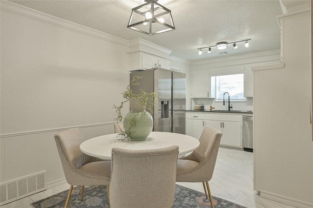 121 NW 79th St, Oklahoma City, OK 73114 - dining space featuring a textured ceiling, ornamental molding, and a chandelier