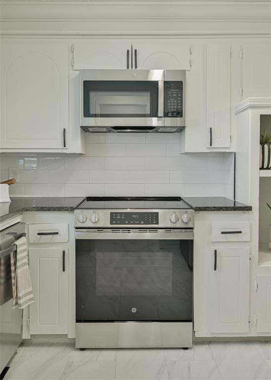 121 NW 79th St, Oklahoma City, OK 73114 - kitchen featuring appliances with stainless steel finishes, light marble finish floors, and white cabinets