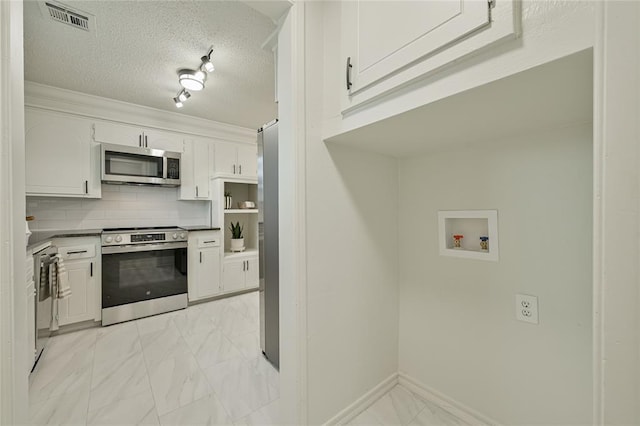 121 NW 79th St, Oklahoma City, OK 73114 - kitchen featuring appliances with stainless steel finishes, light marble finish flooring, white cabinetry, baseboards, and a textured ceiling