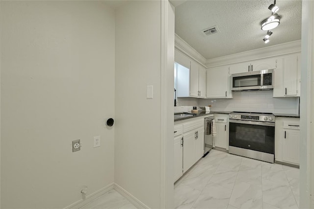 121 NW 79th St, Oklahoma City, OK 73114 - kitchen featuring stainless steel appliances, light marble finish floors, dark countertops, white cabinets, and backsplash