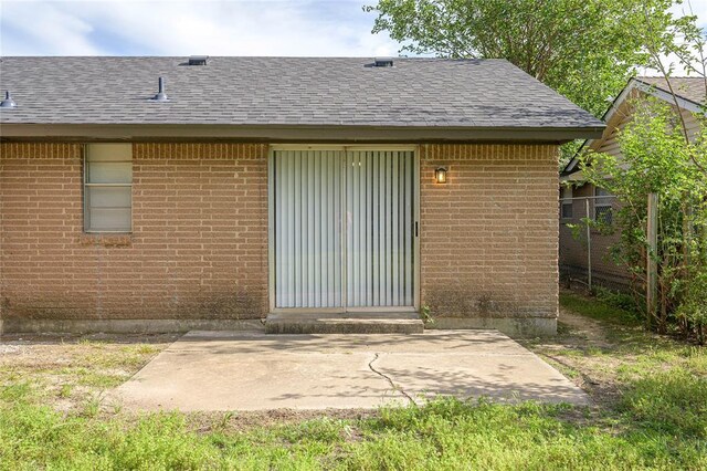 121 NW 79th St, Oklahoma City, OK 73114 - rear view of house featuring roof with shingles, brick siding, and a patio