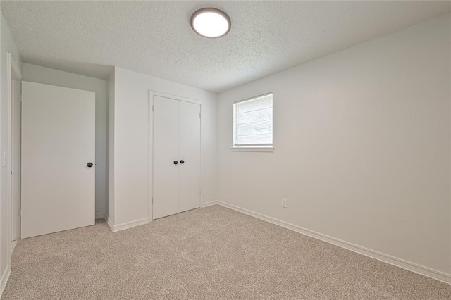 121 NW 79th St, Oklahoma City, OK 73114 - unfurnished bedroom with light colored carpet, a textured ceiling, a closet, and baseboards
