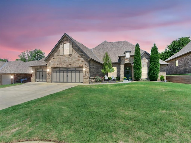 4133 Carmina Dr, Edmond, OK 73034 - french country home with driveway, a front lawn, and brick siding