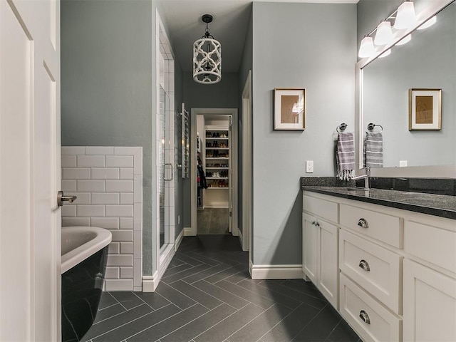 4133 Carmina Dr, Edmond, OK 73034 - bathroom with a stall shower, vanity, baseboards, a soaking tub, and a spacious closet