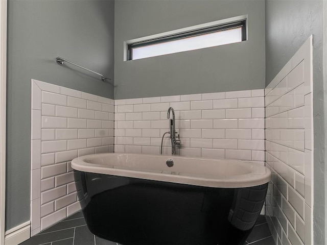 4133 Carmina Dr, Edmond, OK 73034 - full bathroom featuring tile walls, plenty of natural light, tile patterned floors, and a freestanding bath