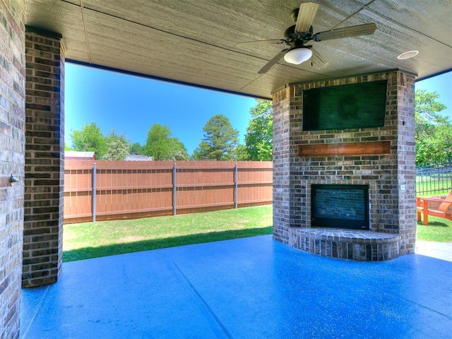 4133 Carmina Dr, Edmond, OK 73034 - fenced backyard with an outdoor brick fireplace, a patio area, and a ceiling fan
