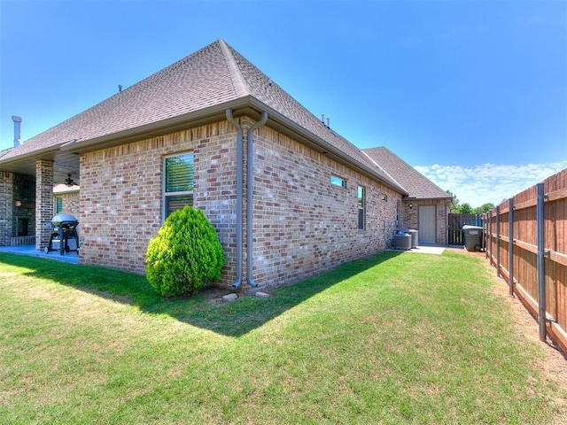4133 Carmina Dr, Edmond, OK 73034 - view of side of home featuring brick siding, roof with shingles, cooling unit, and a patio