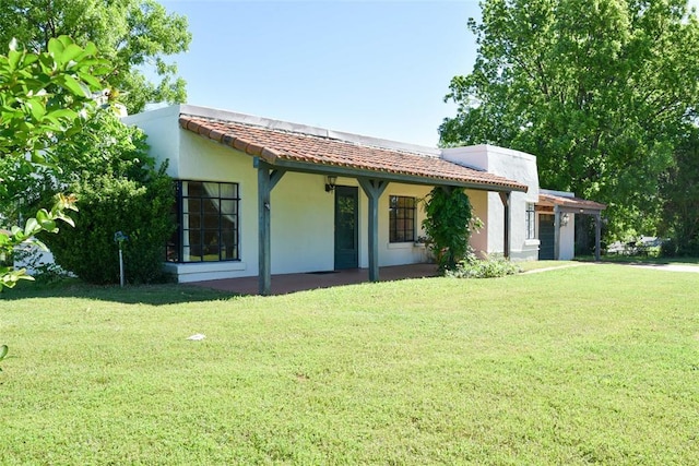 723 W Leslie St, Pauls Valley, OK 73075 - view of front facade featuring a front yard, stucco siding, a tiled roof, and a garage