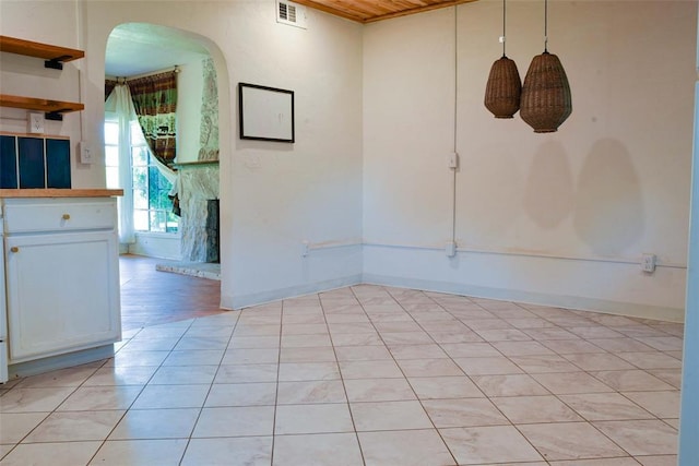 723 W Leslie St, Pauls Valley, OK 73075 - empty room with arched walkways, light tile patterned flooring, and baseboards