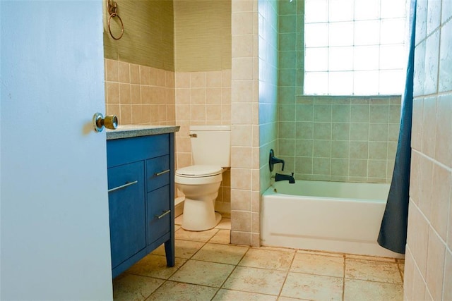 723 W Leslie St, Pauls Valley, OK 73075 - bathroom with toilet, vanity, tile walls, and shower / bath combo with shower curtain