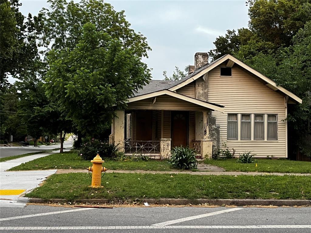 923 N Denver Ave, Tulsa, OK 74106 - view of front of home with a front yard, a porch, and a chimney
