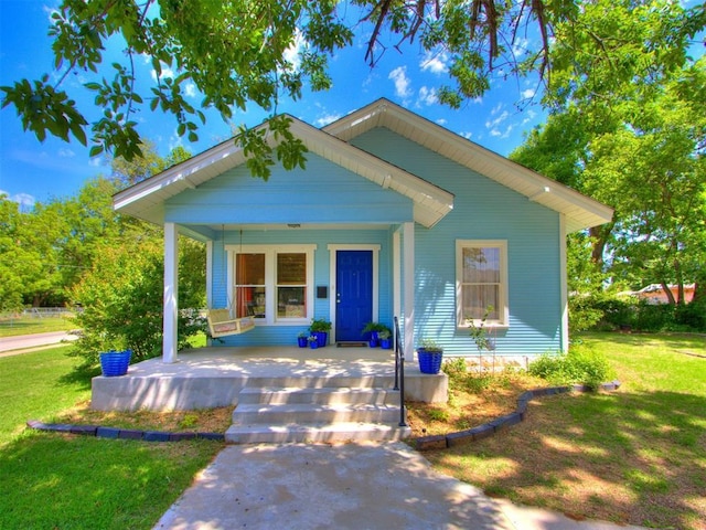view of front of house with covered porch and a front lawn