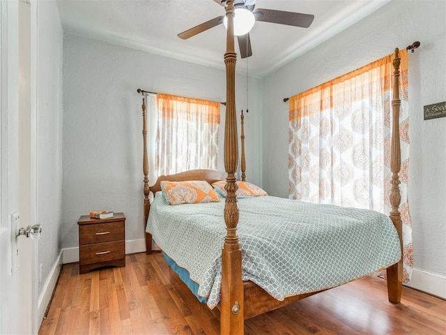 bedroom featuring wood finished floors, baseboards, and ceiling fan
