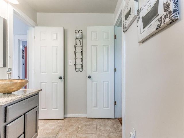 bathroom with tile patterned flooring, vanity, and baseboards