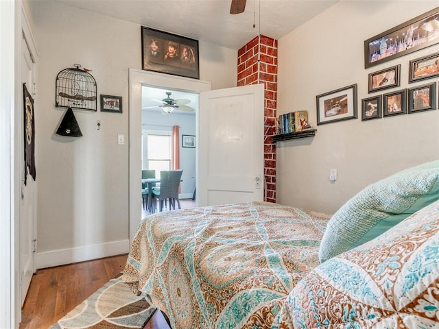 bedroom featuring wood finished floors, baseboards, and a ceiling fan